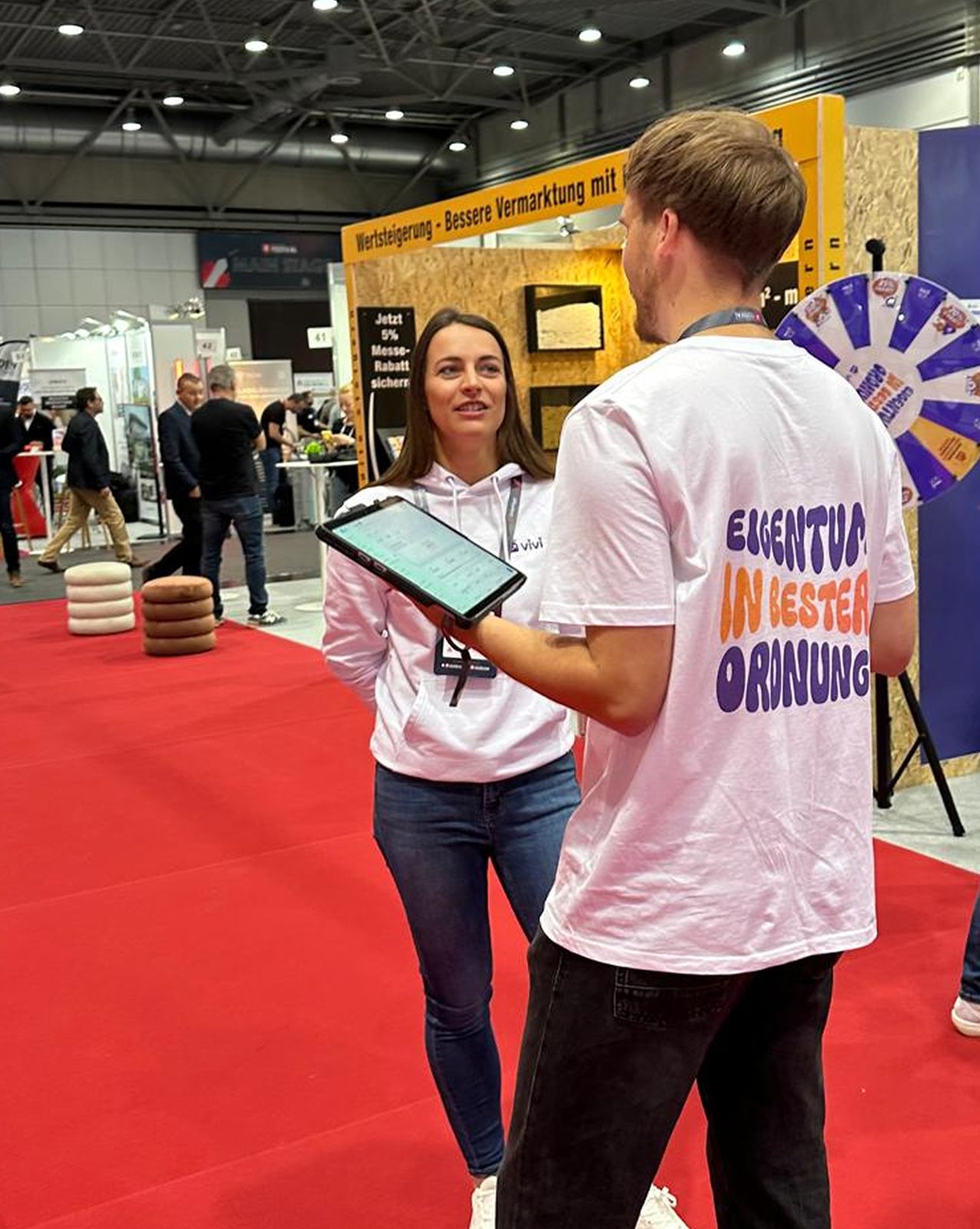 ViVi-Team zeigt die App auf einem Tablet am Messestand des immocation Festivals 2025