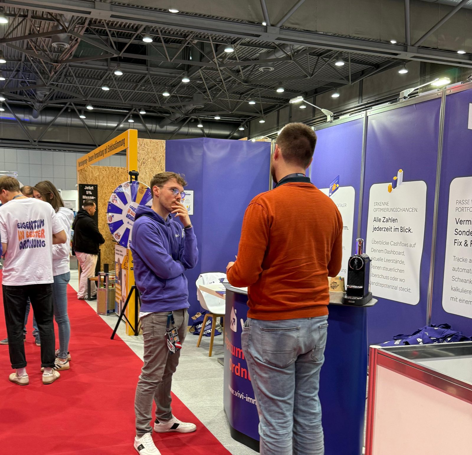 Besucher im Gespräch am ViVi-Messestand auf dem immocation Festival 2025